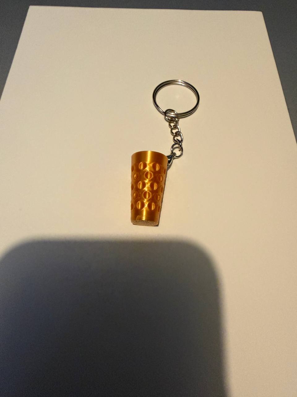 Vorläufiges Original-Produktfoto eines goldfarbenen Dubbenglas-Schlüsselanhängers